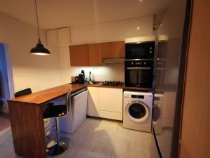 uma cozinha com um fogão e uma máquina de lavar e secar roupa em appartement confortable em Cachan