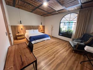 a bedroom with a bed and a table and a chair at Pepe's House Usaquén I Cozy Hotel in Bogotá