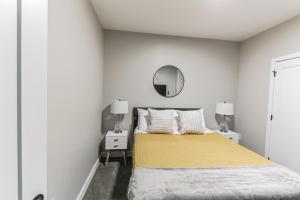 een witte slaapkamer met een bed en een spiegel bij Downtown/Bengals/Reds/TQL/OTR in Cincinnati