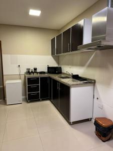 eine Küche mit schwarzen und weißen Schränken und einem Kühlschrank in der Unterkunft Apart hotel JJ - a estrenar in Paso de los Libres