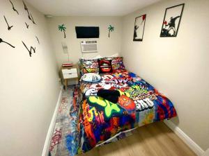 um quarto com uma cama com um edredão colorido em Unique Miami Art Escape w/ HotTub, Arcade & Murals em Miami