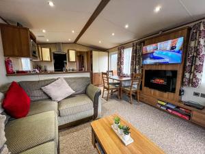 sala de estar con sofá y mesa en Superb Lodge In Rural Norfolk Near Norwich, With Lake Views Fishing Ref 16018h, en Cawston