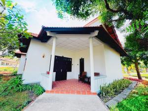 una pequeña casa blanca con entrada de ladrillo rojo en Dat Lanh Beach Resort, en La Gi