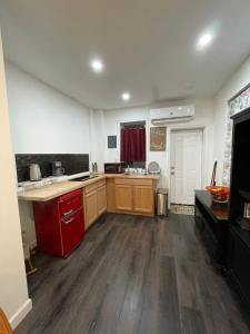 a large kitchen with wooden cabinets and a red appliance at Charming Philly Row 2 Units in Philadelphia