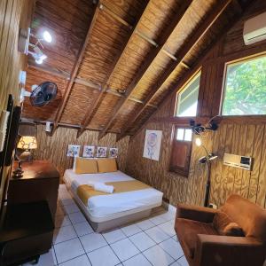 a bedroom with a bed in a room with wooden walls at Casa Campo Obymar/vista panorámica/piscina privada in Moca