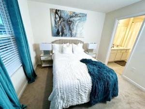 a bedroom with a bed with a blue blanket at Orange Park Townhome Vacation Rental with Patio! in Orange Park