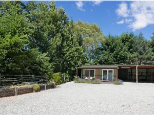 una piccola casa in un terreno ghiaioso con alberi di Wanaka's Private Escape a Wanaka