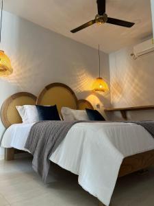 a bedroom with a large white bed with a ceiling at DELAMAR Casa de playa in Coveñas