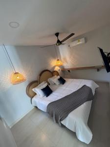 a bedroom with a large white bed with two lamps at DELAMAR Casa de playa in Coveñas