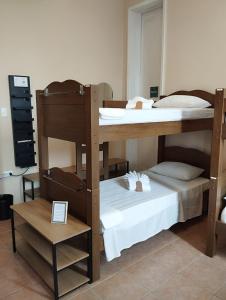 two bunk beds in a room with a table at Casa das Luzes Hostel IVN in Rio de Janeiro