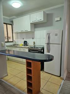 a kitchen with a counter top and a refrigerator at Condominio Florencia 524 in La Serena