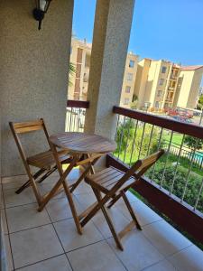 una mesa de madera y una silla en un balcón con vistas en Condominio Florencia 524, en La Serena