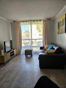 a living room with a couch and a tv at Condominio Florencia 524 in La Serena