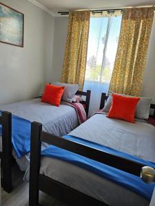 two twin beds in a room with a window at Condominio Florencia 524 in La Serena