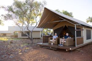 duas pessoas sentadas num sofá num barracão em Bell Gorge Wilderness Lodge em King Leopold Ranges