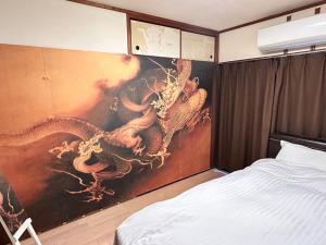 una camera da letto con un dipinto di dragoni sul muro di Nishimoto Building - Vacation STAY 16004v a Hiroshima