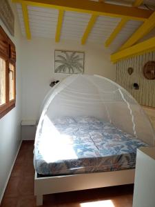 a bed with a canopy in a room at La Mare à Cuja in Sainte-Rose +23 photos