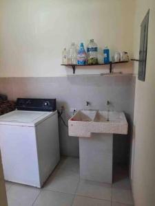 a small kitchen with a sink and a washing machine at Casa cerca de parque industrial in Monclova