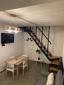 a living room with a table and a staircase at Depto funcional en Comodoro! in Comodoro Rivadavia