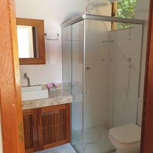 a bathroom with a shower and a toilet and a sink at Tiny house in Porto Seguro