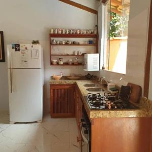 a kitchen with a white refrigerator and a stove at Tiny house in Porto Seguro
