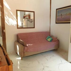 a bed in a room with a mirror on the wall at Tiny house in Porto Seguro