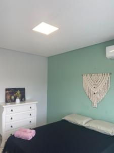 - une chambre avec un lit et une commode blanche dans l'établissement Recanto aconchegante no Campeche Apart 05 - 50m da praia -, à Florianópolis