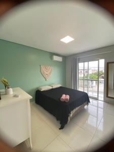 Un dormitorio con una cama con zapatos rosados. en Recanto aconchegante no Campeche Apart 05 - 50m da praia -, en Florianópolis
