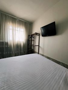 1 dormitorio con 1 cama y TV de pantalla plana en Casa alto Vidigal, en Río de Janeiro