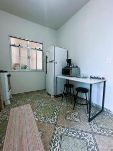 a kitchen with a table and a refrigerator at Casa alto Vidigal in Rio de Janeiro