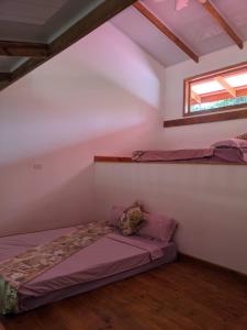 a bedroom with a bed and a window in a attic at Playa Bluff Lodge in Bocas Town