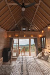 a bedroom with a large bed and a balcony at Garden Terrace Bali in Gobleg