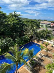 Phra Ae beachにある2 Bedroom Seaview Apartment Lanta Sport Resort 305のヤシの木が茂るスイミングプールの上からの眺め