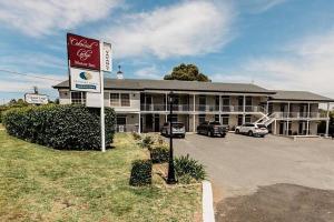 un motel con coches aparcados frente a un edificio en Colonial Lodge Motor Inn, en Yass