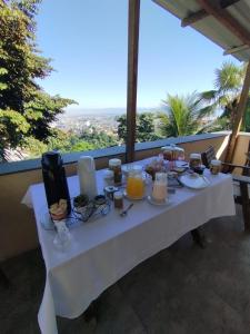 リオデジャネイロにあるCasa das Luzes Hostel IVNの白いテーブル(バルコニーに食べ物とキャンドル付)