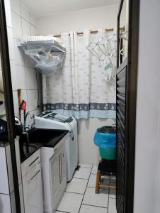 eine kleine Küche mit Spüle und Waschmaschine in der Unterkunft De Frente para o Atlântico in Bombinhas