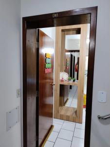 einen Flur mit Tür und Spiegel in der Unterkunft De Frente para o Atlântico in Bombinhas