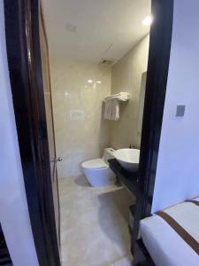 a bathroom with a toilet and a sink and a tub at Kingdom Danang Hotel in Da Nang