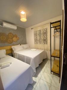 una camera con due letti e uno specchio di Casa da Praia Japaratinga a Japaratinga