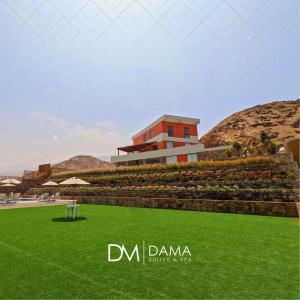 a view of a building with green grass at Dama Suites & Spa in Cieneguilla