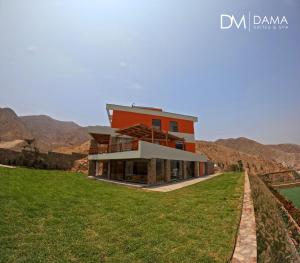 una casa en una colina con montañas en el fondo en Dama Suites & Spa, en Cieneguilla