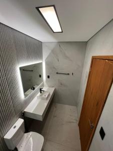 ein Badezimmer mit einem Waschbecken, einem WC und einem Spiegel in der Unterkunft Sítio São Mateus in Caparaó