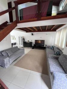 a living room with two couches and a flat screen tv at Casa completa cond. fechado em Paúba, S. Sebastião in São Sebastião