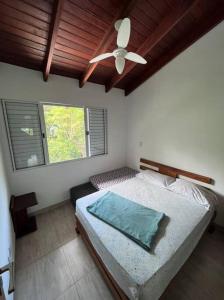 Casa completa cond. fechado em Paúba, S. Sebastião في ساو سيباستياو: غرفة نوم بسرير ومروحة سقف