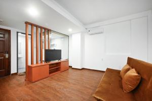 a living room with a couch and a flat screen tv at YoKo Airport Saigon Hotel in Ho Chi Minh City