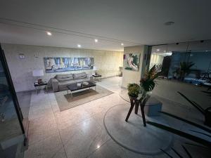 een woonkamer met een bank en een tafel bij Flat Novo e Moderno a 200m do Shopping , com Piscina wifii 500mbps in Recife