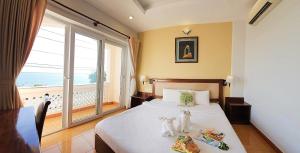 a bedroom with a bed with a large window at Ocean Valley Hotel in Mui Ne