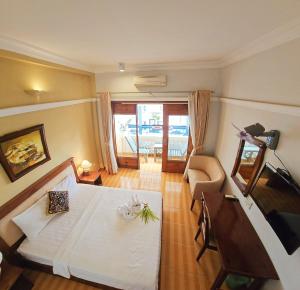 a bedroom with a white bed and a living room at Ocean Valley Hotel in Mui Ne