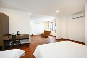 - une chambre avec un lit, un bureau et une chaise dans l'établissement YoKo Airport Saigon Hotel, à Hô-Chi-Minh-Ville