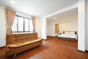 - un salon avec un canapé et un lit dans l'établissement YoKo Airport Saigon Hotel, à Hô-Chi-Minh-Ville